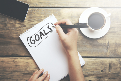 Goals,Memo,Written,On,A,Notebook,With,Woman,Hand,Pen